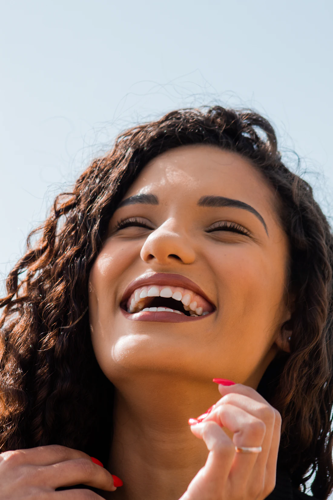 Mulher de cabelo cacheado sorrindo